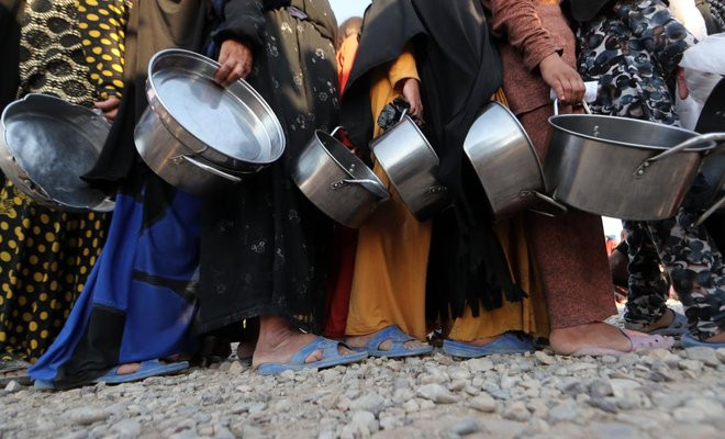 Những người dân sống tại trại tị nạn Khazir xếp hàng nhận thực phẩm cứu trợ trong tháng Ramadan. Ảnh: AFP