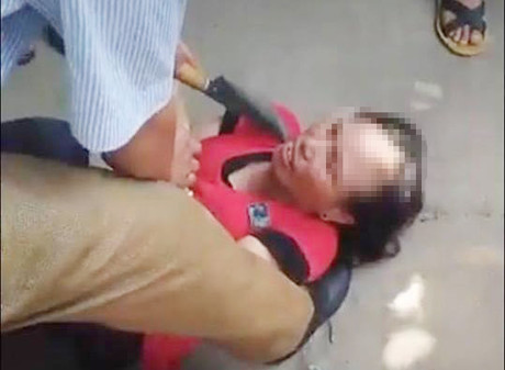 Người phụ nữ bị người dân dí dao vào cổ để tra khảo.