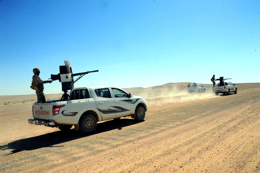 Lực lượng trung thành với Tổng thống Syria Bashar Assad di chuyển trên các xe tải được trang bị vũ khí ở Badia, một vùng sa mạc ở đông nam Syria, ngày 13/6/2017