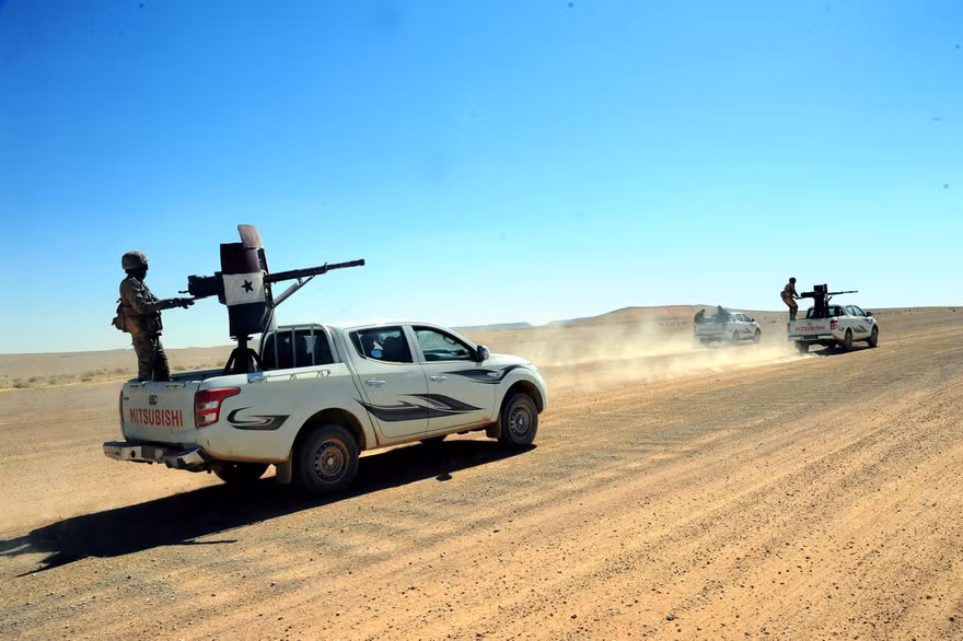 Lực lượng trung thành với Tổng thống Syria Bashar Assad di chuyển trên các xe tải được trang bị vũ khí ở Badia, một vùng sa mạc ở đông nam Syria, ngày 13/6/2017