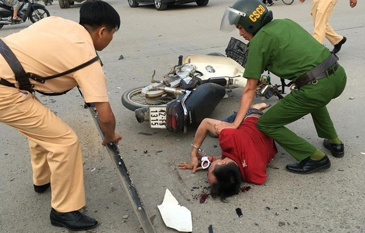 Tên cướp bị bắt khi liều vượt đèn đỏ, đâm vào xe ô tô, ngã xuống đường. Ảnh: Thanh Loan.