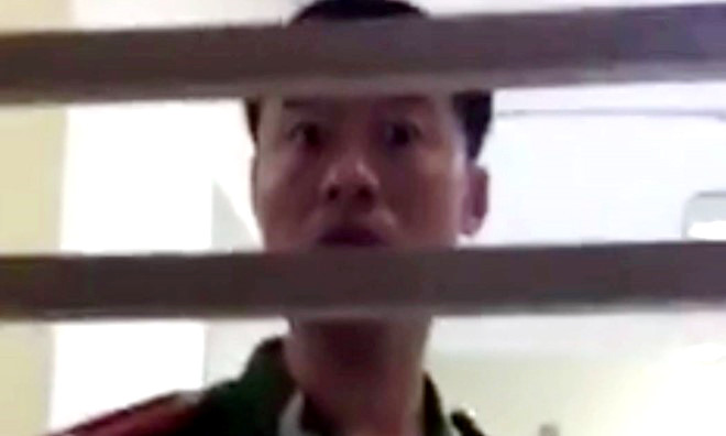 Người mặc sắc phục nhổ nước bọt trước mặt dân. Ảnh cắt từ clip