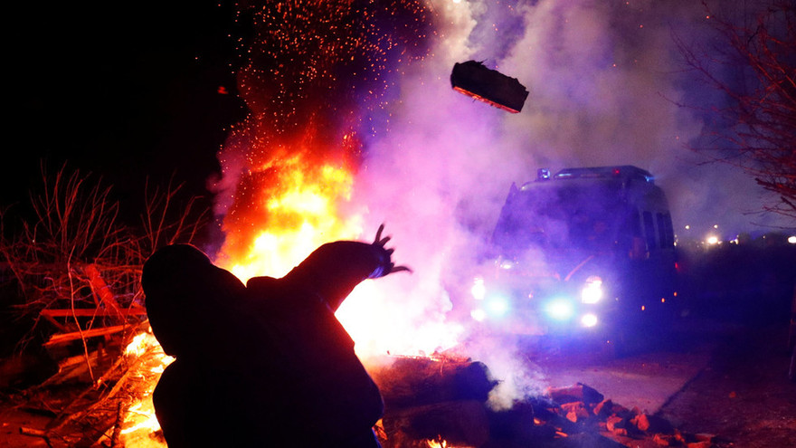 Người dân tấn công xe buýt chở người sơ tán ở Novye Sanzhary ngày 20/2. Ảnh: Reuters