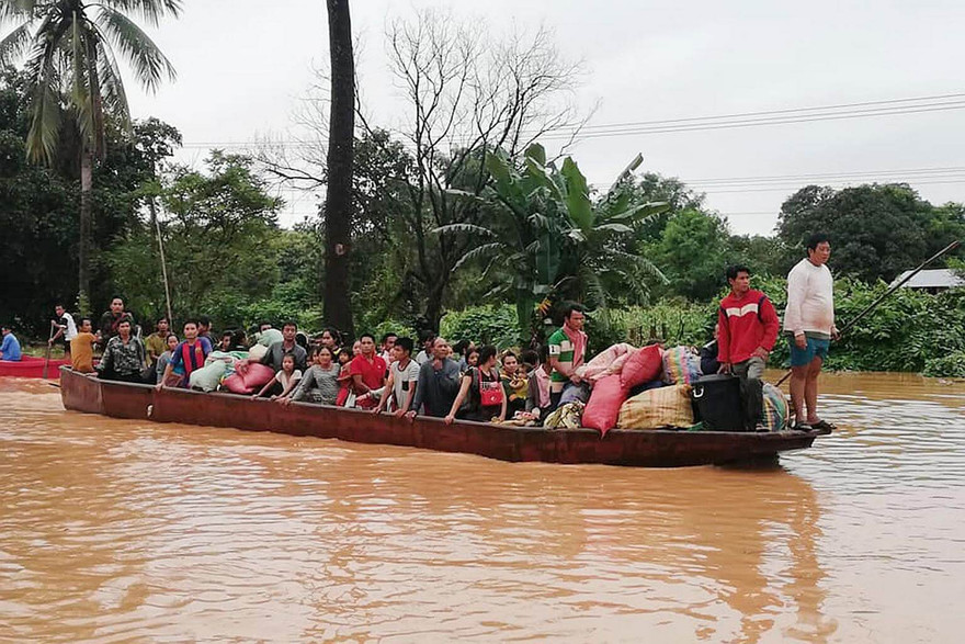 Người dân sơ tán sau sự cố vỡ đập. Ảnh: AFP