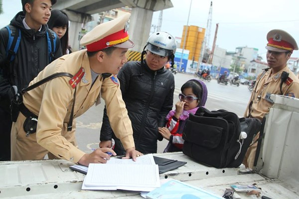 Lực lượng CSGT xử phạt trường hợp không đội MBH cho trẻ em. Ảnh: Thanh Hà