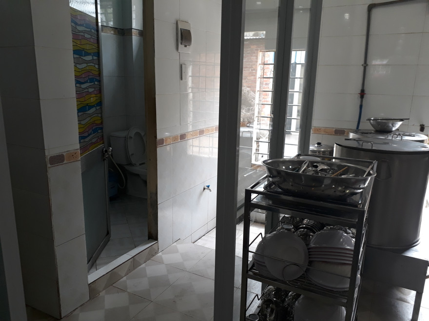 Khu vực chế biến thức ăn của quán cơm nằm ngay cửa nhà vệ sinh