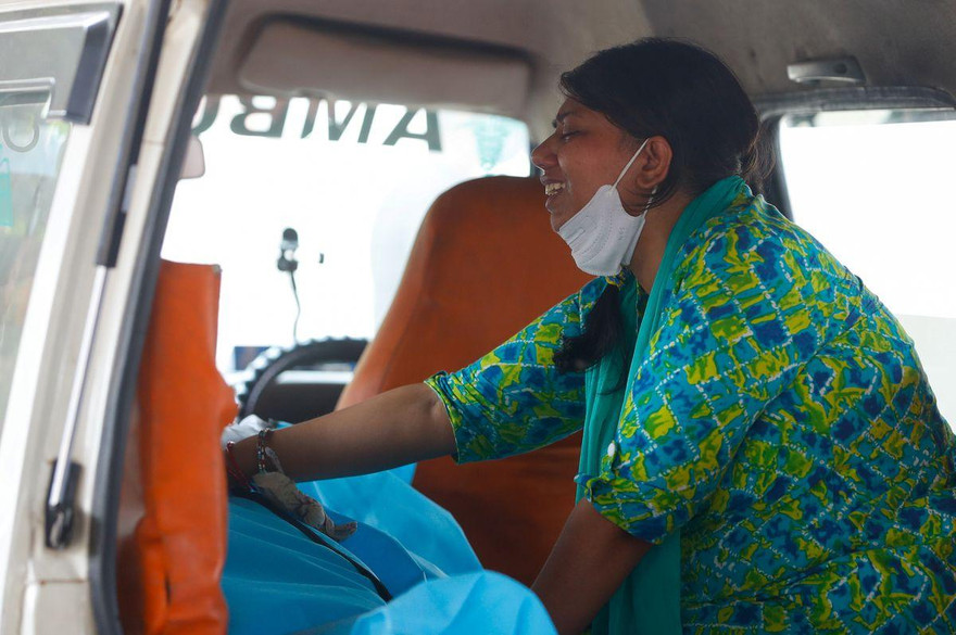 Một phụ nữ Ấn Độ khóc nấc khi thấy chồng qua đời vì COVID-19 trong xe cứu thương. Ảnh: Reuters