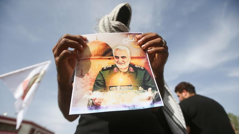 Một binh sĩ cầm ảnh chân dung của Tướng Qassem Soleimani. Ảnh: Reuters