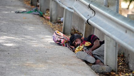 Một người đàn ông mệt lả nằm ven đường bởi nắng nóng.