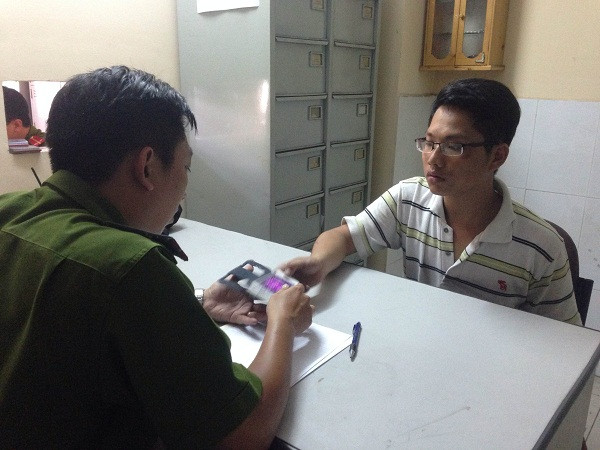 Nghi can Minh tại cơ quan công an. Ảnh H.Hưng