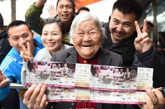 Cụ bà vui mừng khi mua được hai tấm vé xem bóng đá cho con.