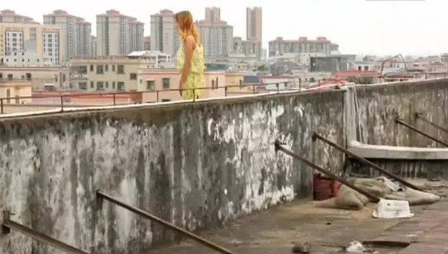 Nữ nhân viên đứng trên cục nóng điều hòa và đe dọa sẽ nhảy xuống từ sân thượng.