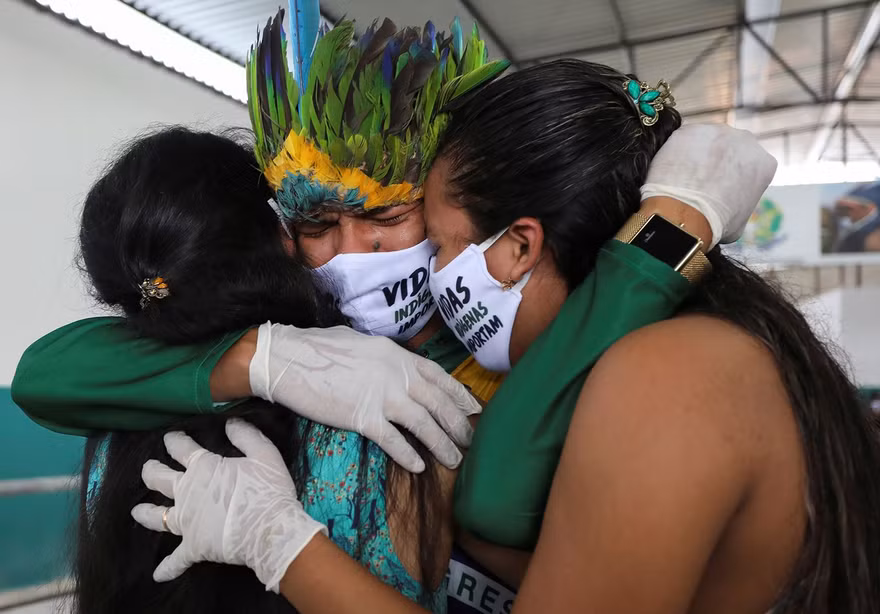 Anh Miqueias Moreira Kokama, con trai tù trưởng Messias Kokama, ôm người thân trong đám tang bố ở thành phố Manaus của Brazil hôm 14/5. Tù trưởng qua đời ở tuổi 53. Ảnh: Reuters.