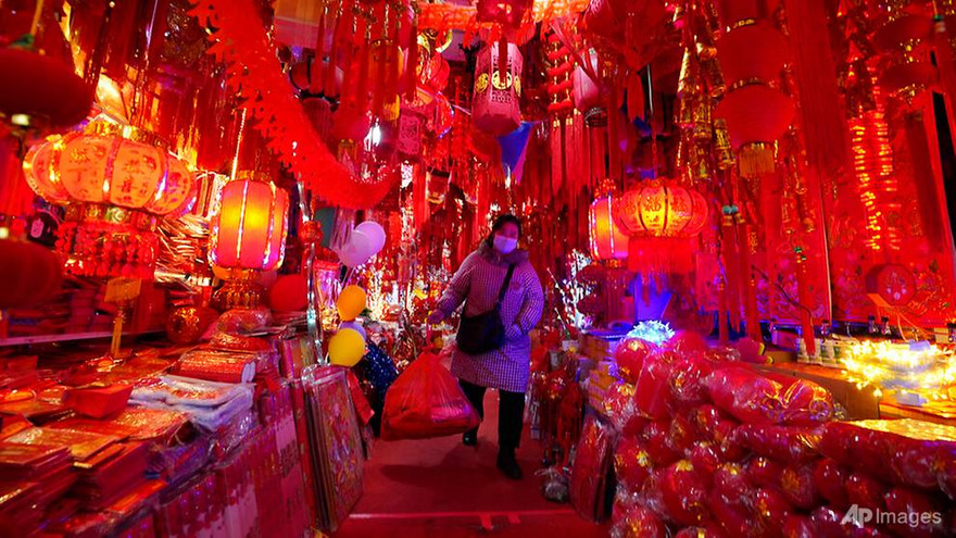 Một tiểu thương Vũ Hán đeo khẩu trang bán hàng. Ảnh: AP