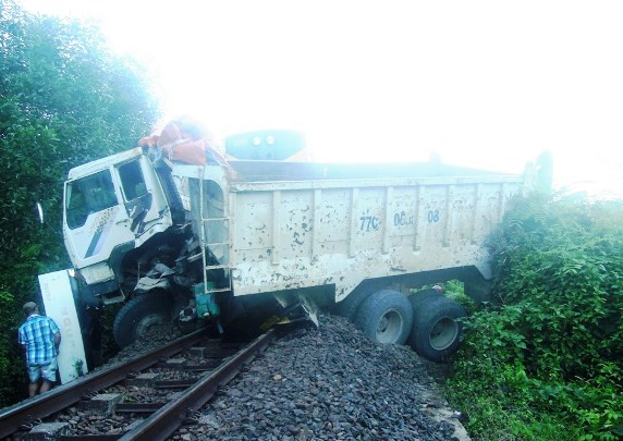 Chiếc xe ben bị tàu lửa tông nằm chắn ngang đường sắt. Ảnh: BĐO