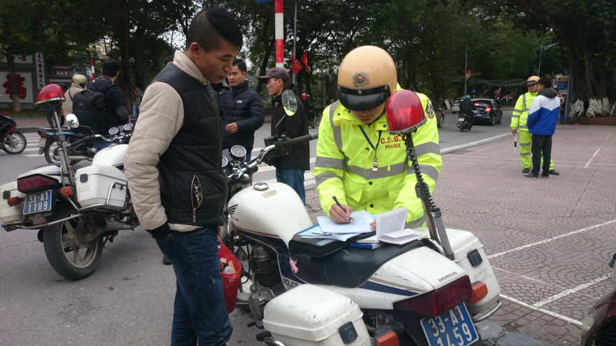 Lực lượng CSGT lập biên bản xử phạt người đi bộ.