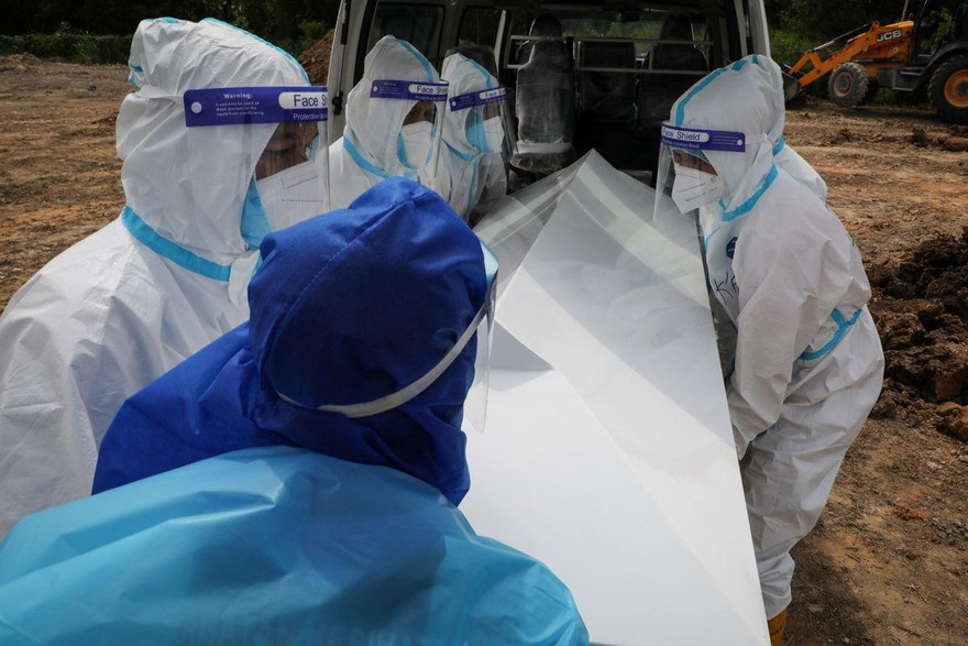 Nhân viên nhà tang lễ mặc đồ bảo hộ khi chôn cất bệnh nhân COVID-19 tại một nghĩa trang ở Klang (Malaysia). Ảnh: Reuters