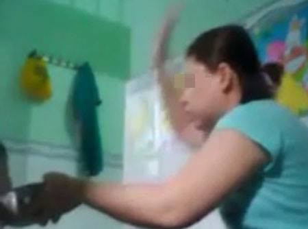 Bảo mẫu ra tay đánh các bé trong lúc cho ăn - Ảnh Cắt từ clip. 