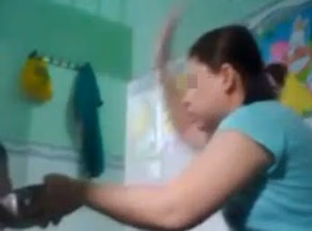 Bảo mẫu ra tay đánh các bé trong lúc cho ăn - Ảnh Cắt từ clip. 