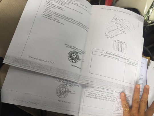 Giấy tờ thật (phía dưới) cập nhật chủ sở hữu mới tên Trần Thanh Sơn và giấy tờ giả bị lừa đảo đánh tráo của ông T.