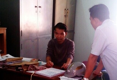 Ngọc (ngồi) tại trụ sở công an