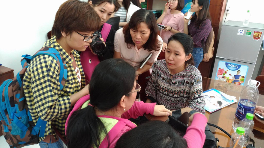 Phụ huynh (người đeo kính, quay mặt) đang trao đổi với PV sáng 13/3.