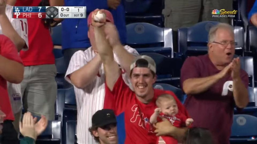 CĐV gây sốc khi vừa ôm con nhỏ vừa bắt bóng trên khán đài