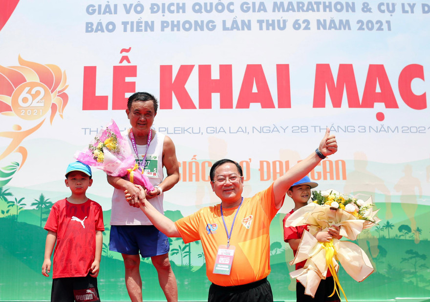 Nhà báo Lê Xuân Sơn - Tổng Biên tập Báo Tiền Phong, Trưởng Ban Tổ chức Tiền Phong Marathon 2021 chúc mừng ông Nguyễn Văn Phúc - vận động viên lớn tuổi nhất hoàn thành cự ly 42,195km của giải. Ảnh: Dương Triều.