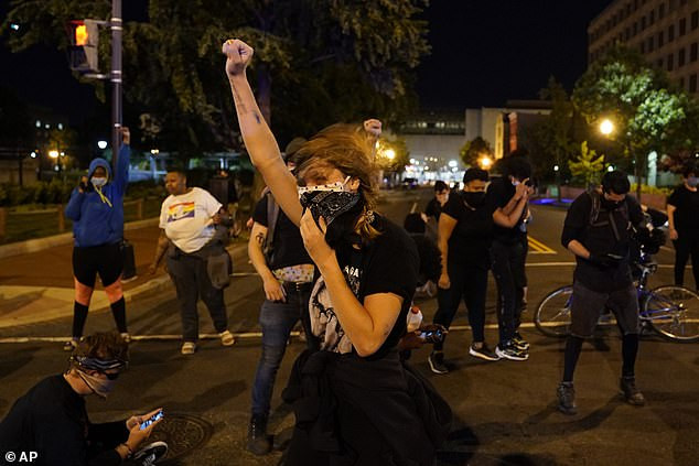 Người biểu tình cố tìm cách đứng vững dưới sức gió trực thăng. Ảnh: AP