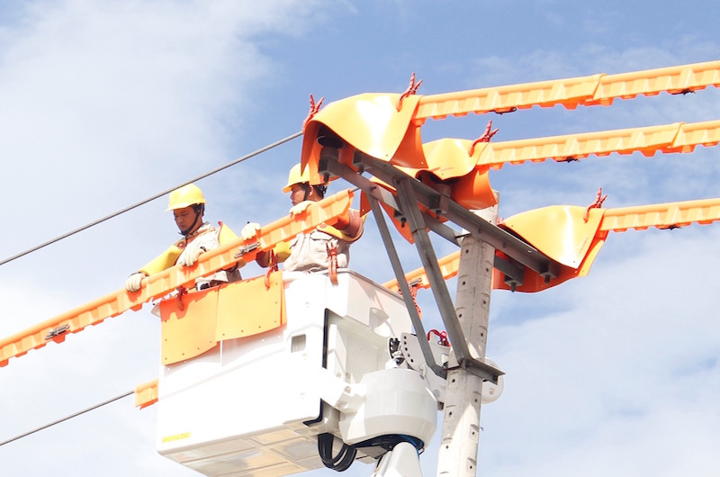Công nhân tiến hành sửa chữa điện trực tiếp trên đường dây mang điện. Ảnh: Thanh Trần. 