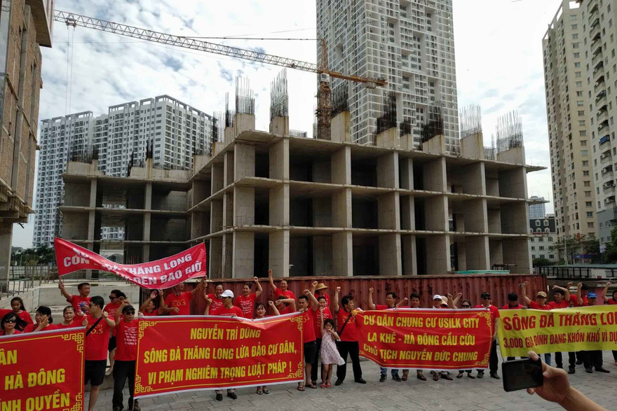 Hàng trăn khách hàng căng băng rôn đòi nhà. Ảnh: Minh Đức