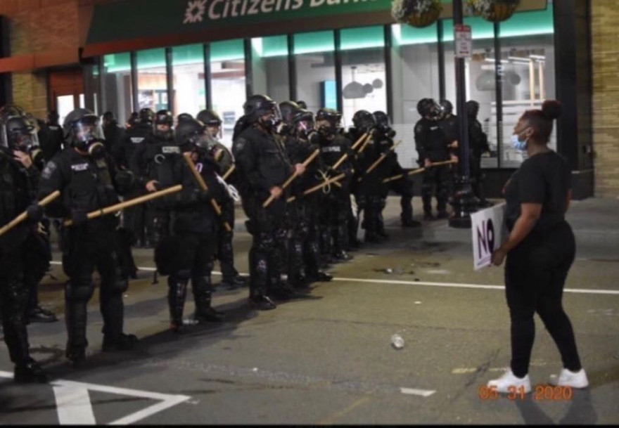 Một người biểu tình đứng trước hàng rào cảnh sát trên phố Elm, thành phố Manchester, bang New Hampshire ngày 31/5. Ảnh: Thanh Tâm.