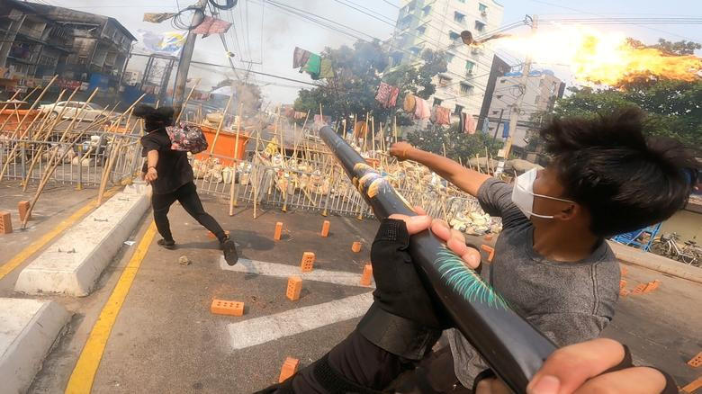 Người biểu tình ném bom xăng ở Yangon. Ảnh: Reuters