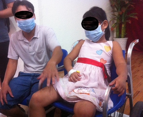 Bé V. và người nhà. Ảnh: Quốc Ngọc