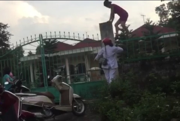 Hình ảnh cán bộ, nhân viên trung tâm tuồn quà từ thiện của trẻ khuyết tật ra ngoài. Ảnh cắt từ clip.