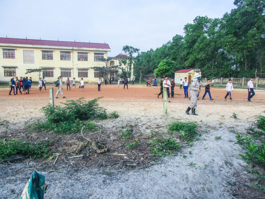 Nhân viên Đội xử lý bom mìn lưu động số 4 hướng dẫn các em học sinh di chuyển đến nơi an toàn. Ảnh: Kim Chiến.