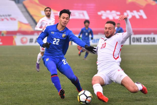 Cầu thủ Thái Lan (trái) tranh chấp bóng với một chân sút Palestine. Ảnh: Bangkok Post
