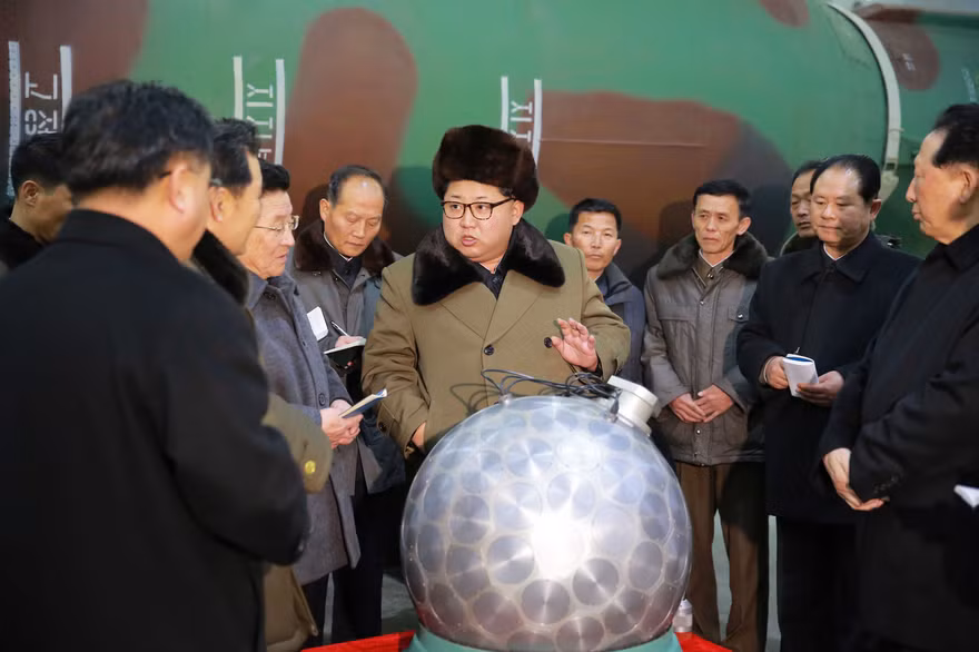 Chủ tịch Triều Tiên Kim Jong-un (giữa) nói chuyện về các nhà khoa học và chuyên viên kĩ thuật về mô hình đầu đạn hạt nhân, được Bình Nhưỡng gọi là "quả cầu disco". Ảnh: KCNA