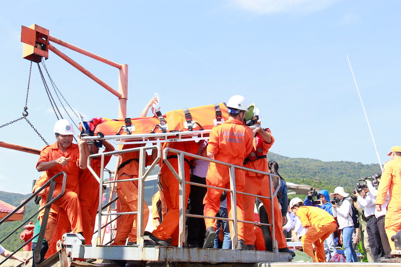 Thuyền viên tàu SAR 412 đưa một ngư dân trên biển vào bờ. Ảnh: Thanh Trần.