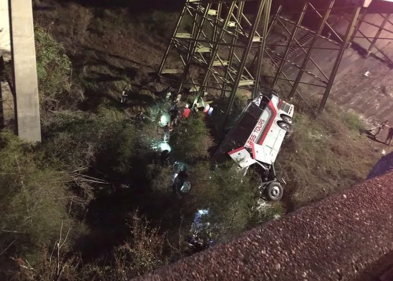 Chiếc xe buýt lật nghiêng dưới chân vách núi. Ảnh: Twitter