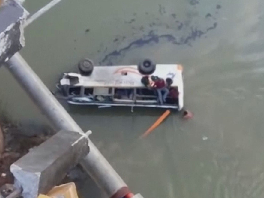 Chiếc xe buýt lật nghiêng khi rơi xuống sông. Ảnh: Sky News