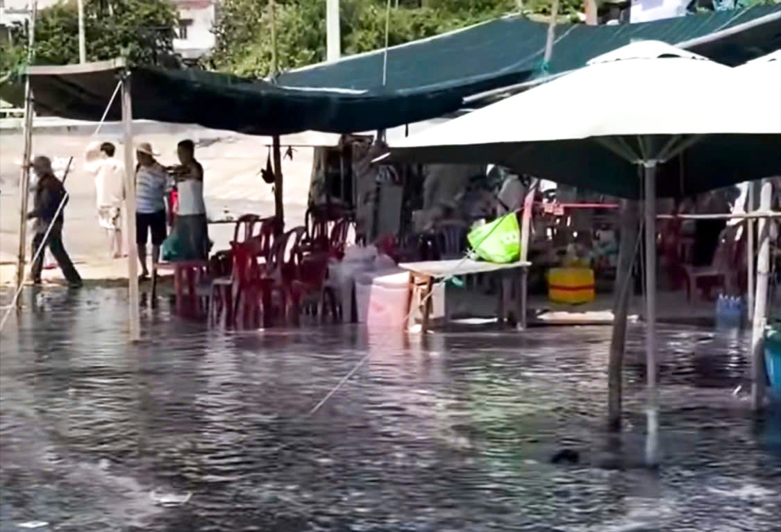 Nước đen ngòm chảy tràn ra khu vực buôn bán của người dân trên bãi biển. hinh-2.jpg