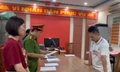 Nguyễn Thành Long (áo trắng) tại cơ quan công an.