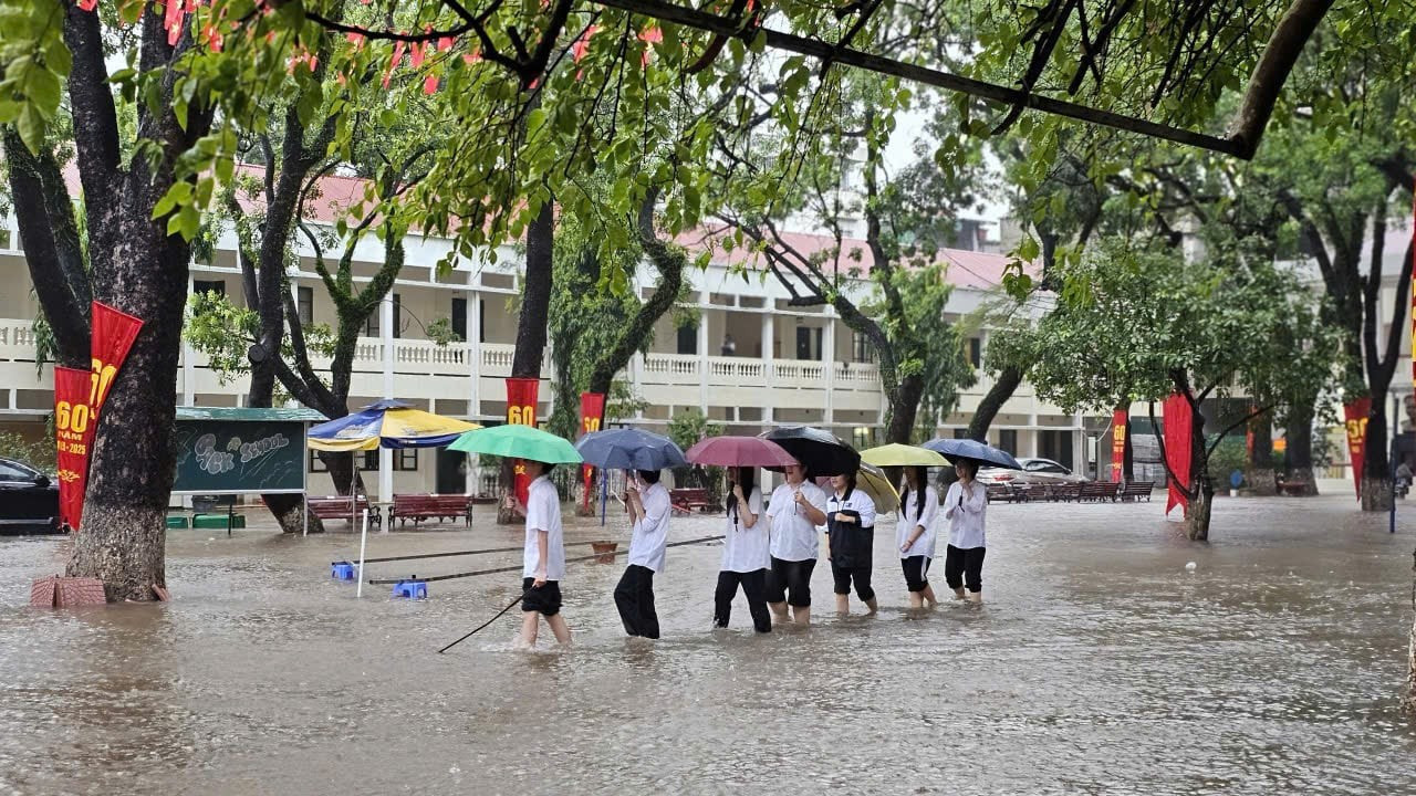 ハノイの学校の生徒たちが雨と洪水の中、下校している。写真:NVCC。 Học sinh một trường học ở Hà Nội ra về trong mưa ngập. Ảnh: NVCC.