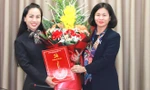 Phó Bí thư Thường trực Thành ủy Hà Nội Nguyễn Thị Tuyến (bên phải) trao quyết định và tặng hoa cho bà Phạm Thị Mỹ Hoa.