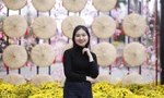 Các bạn trẻ chụp ảnh lưu niệm tại mô hình nón quai thao ở đường hoa Tết. Ảnh: Nguyễn Thắng.