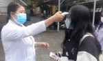 Đo thân nhiệt học sinh trước khi vào lớp tại Trường THPT Nguyễn Trường Tộ, Huế, vào sáng 13/12