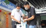 Anh Mai Anh Ðức (trái) thử nghiệm máy khử khuẩn di động. Vì máy biến dung dịch thành hơi sương siêu mịn nên không gây ướt quần áo khi khử khuẩn. Ảnh: Giang Thanh