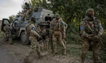 Lính Ukraine đứng gần chiếc xe quân sự ở khu vực gần biên giới Nga ngày 16/8. (Ảnh: Reuters)