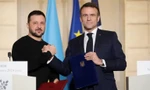 Tổng thống Pháp Emmanuel Macron và người đồng cấp Ukraine Volodymir Zelensky khi ký thỏa thuận an ninh tại Paris. (Ảnh: Reuters)